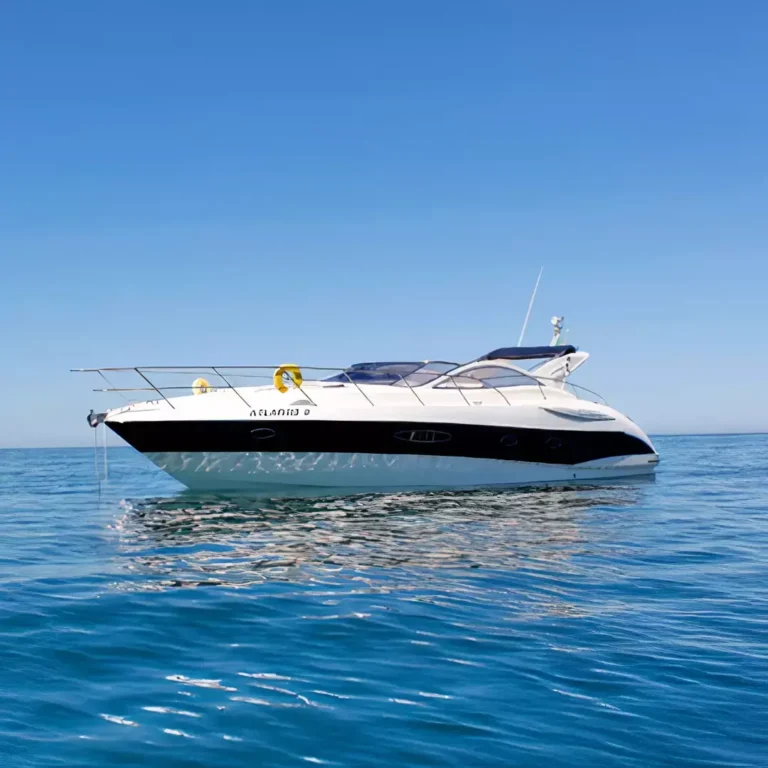 Luxury motor yacht Atlantis II sailing on the sea under clear blue skies with people enjoying their time on deck.