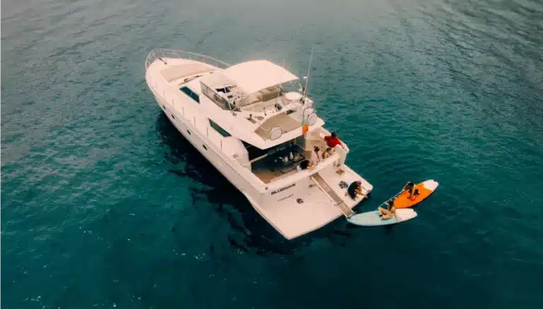 Aerial view of the luxury yacht Blue Days, with people enjoying water sports and leisure activities on clear blue water.