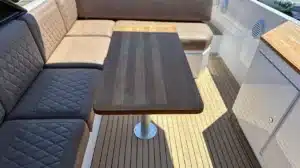 Luxury furnishings on a boat deck in Algarve with a rectangular wooden table and cushioned benches in a two-tone color scheme.