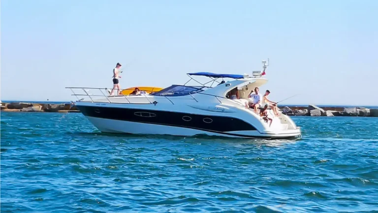 Group of people enjoying leisure activities on Jacky Louise motor yacht at Marina de Portimão on a sunny day with clear skies and calm waters.