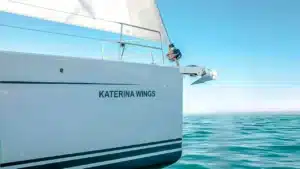 The sailing yacht Katerina Wings glides on calm blue waters near Cascais Marina under a clear sky.