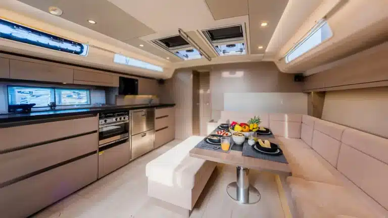 Interior of Katerina Wings yacht featuring a modern galley with stainless steel appliances and a cozy dining area at Cascais Marina, Portugal.