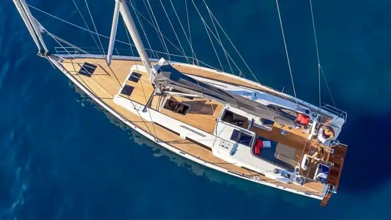 Bird's-eye view of Katerina Wings, a luxury sailing yacht, with spacious deck and individuals enjoying themselves in Cascais Marina.