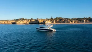 Mr Cliff luxury yacht cruising near the sandy coastline of Marina de Vilamoura.