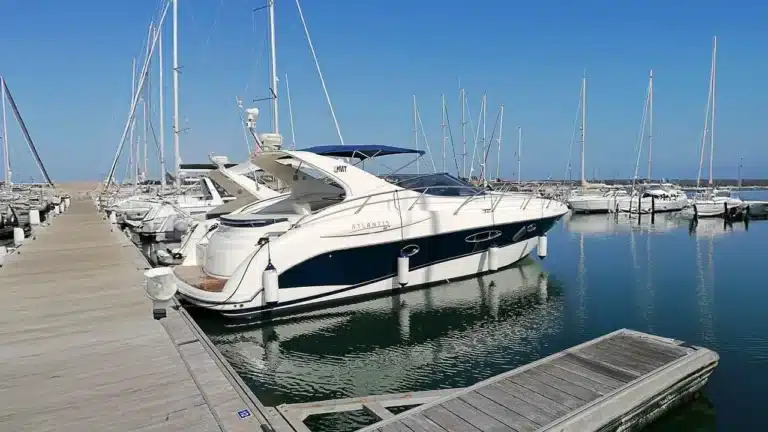 Powerboat ATLANTIS 38 docked at Marina de Portimão on a sunny day, with sailboats and powerboats in sight.