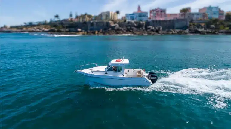 Fishing Katerina yacht speeding over the blue waters near Cascais Marina with a clear sky in the background, creating an exhilarating maritime experience.