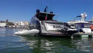 Yacht Baco IV moored at Marina de Vilamoura in a beautiful day, featuring a personal watercraft and stunning coastal buildings in the background.